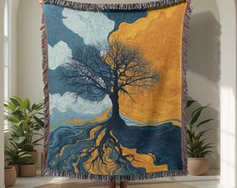 Könnte beinhalten: Eine gewebte Decke mit einem stilisierten Baumdesign. Das Kunstwerk zeigt einen Baum mit freiliegenden Wurzeln, vor einem Hintergrund aus blauen, gelben und orangen Farbtönen. Die Decke hat einen Fransenrand.