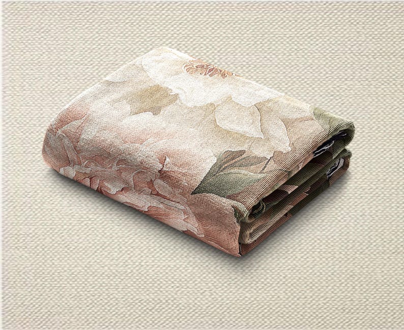 May include: Folded floral fabric with a peony design in pink, white, and green. The fabric is folded neatly, displaying the detailed print of the flower and leaves. The folded fabric is on a neutral background.
