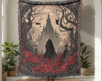 Könnte beinhalten: Gewebte Überwurfdecke mit einer gotischen Szene mit einer Burg, einer Figur in einem Umhang und roten Rosen. Das Design umfasst kahle Bäume, Grabsteine und Krähen, mit einem Fransenrand. Die Farbpalette ist hauptsächlich Schwarz, Grau und Rot.