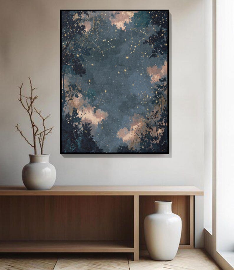 May include: A framed art print shows a night sky with constellations and golden stars, framed by silhouetted trees. The artwork is displayed above a wooden console with white vases. The print's colour palette includes dark blue and soft peach.