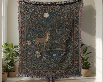 Könnte beinhalten: Eine gewebte Wohndecke mit einer dunklen, detaillierten Waldszene und einem zentralen Hirsch an einem Teich. Das Design zeigt einen Vollmond, einen Steinbrunnen, Obstbäume und florale Elemente, eingerahmt von einer dekorativen Bordüre mit Fransen.