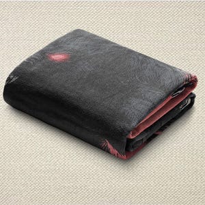 May include: Folded black wallet with a textured surface. The interior and edges are a contrasting pink colour. The wallet appears to be made of a durable material.