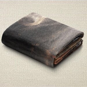 May include: Folded wallet with a detailed, textured print. The wallet features a dark, blended color scheme with shades of black, brown, and gray. The design appears to be a close-up of a textured surface.