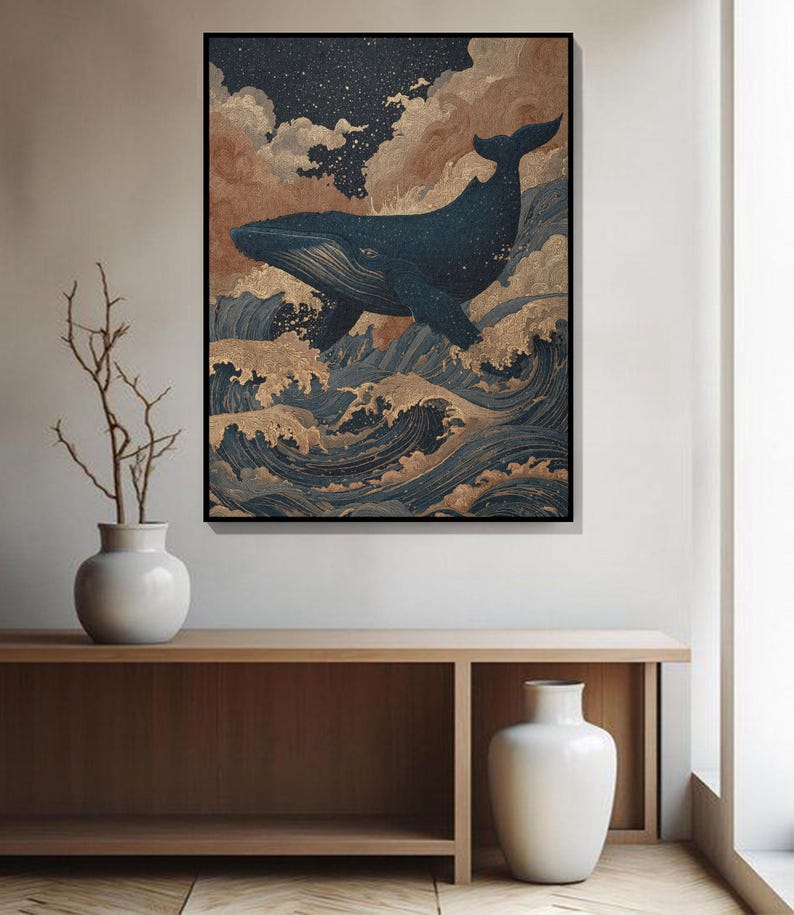 May include: A framed art print depicts a dark blue whale leaping above stylized ocean waves. The artwork features a starry sky, clouds, and gold accents, creating a serene and artistic scene. The print is displayed on a wooden console.