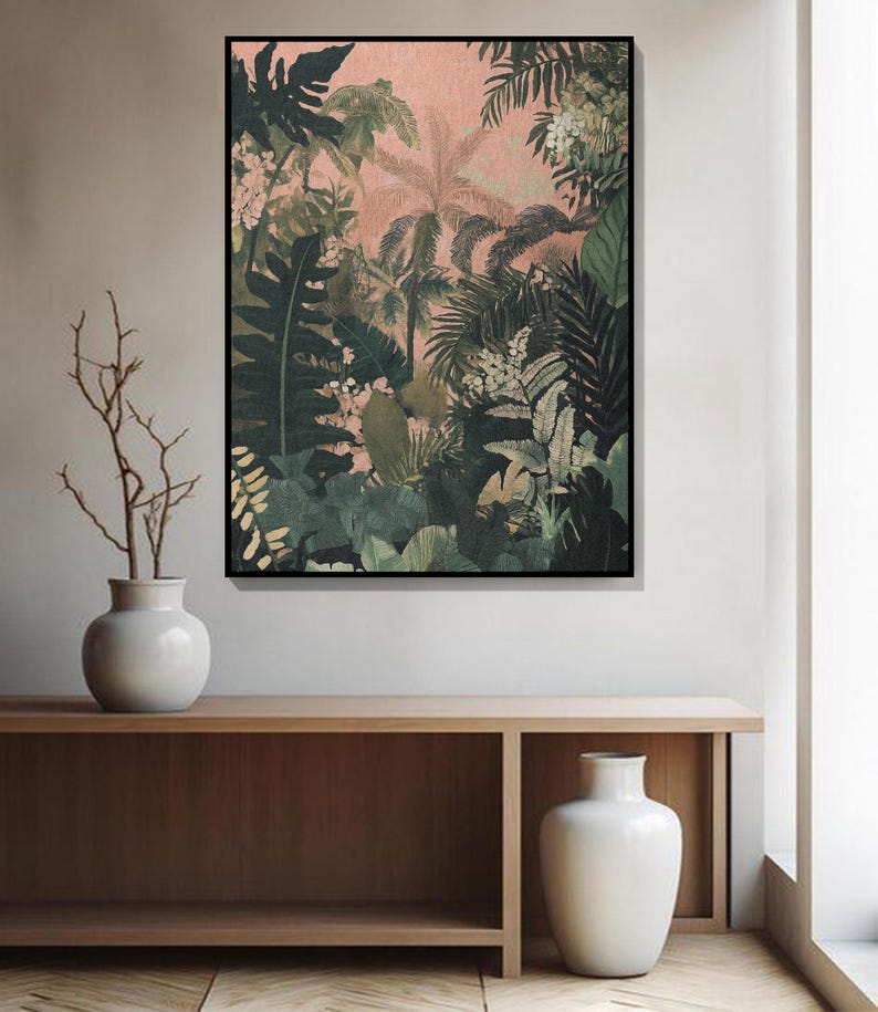 May include: A framed botanical print depicting a dense jungle scene with diverse green foliage and palm trees set against a pale pink backdrop. The artwork is displayed above a wooden console with two white vases.