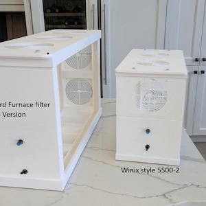 May include: Two white rectangular air purifier housings with circular fan grilles. The larger unit is labeled Standard Furnace filter 16 x 25 Version, and the smaller unit is labeled Winix style 5500-2. Both feature small blue and black knobs.
