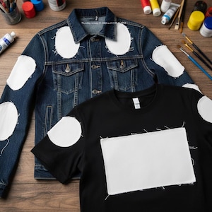May include: A dark blue denim jacket and a black t-shirt, both with large white patches sewn on. The jacket has a button-up front and pockets. Paint tubes, brushes, and paint are scattered around the clothing on a wooden surface.