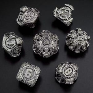 May include: Seven silver-colored, multi-sided dice with a steampunk aesthetic. Each die features intricate gear and cog designs, with numbers displayed in a bold, easy-to-read font. The dice are arranged on a dark surface, showcasing their detailed craftsmanship.