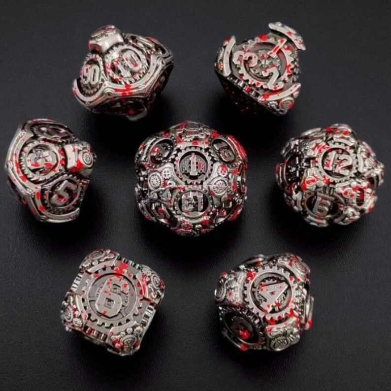 May include: Set of seven metallic dice with a steampunk aesthetic. The dice are silver with red accents and feature intricate gear and cog designs. Numbers are displayed in a stylized font.