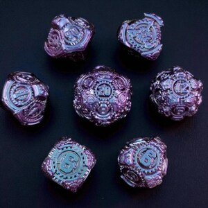 May include: Seven iridescent purple and blue dice with intricate gear and number designs. The dice are multi-sided, with numbers like 6, 12, 20, and 90 visible. The dice are set against a dark background.