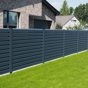 May include: A dark gray horizontal slat fence in front of a house with a brick facade and green lawn. The fence is made of evenly spaced horizontal slats and is a modern design.