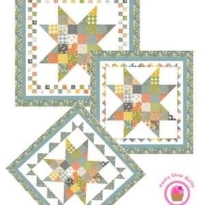 May include: Three quilt patterns with star designs. The quilts feature a patchwork star in the center, surrounded by a patterned border. The text "Charmed Star" is at the top. The quilts are available in 38" or 58" square sizes.