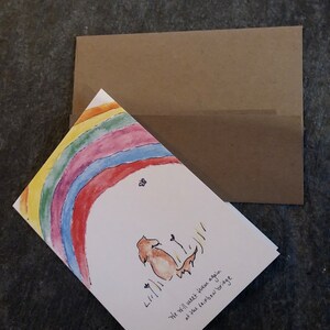 May include: A sympathy card with a rainbow and a dog sitting under it. The card says "We will meet your again at the rainbow bridge".