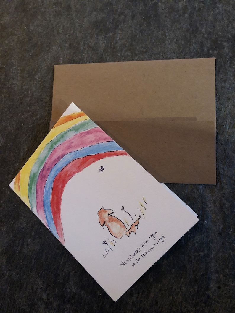 May include: A sympathy card with a rainbow and a dog sitting under it. The card says "We will meet your again at the rainbow bridge".