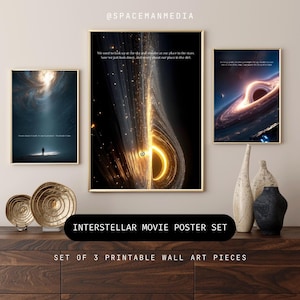 May include: A set of three framed Interstellar movie posters. The posters feature cosmic imagery with gold frames. One poster shows a person in a bright light, another depicts a black hole, and the third shows a swirling galaxy. The text reads, "We used to look up at the sky and wonder at our place in the stars."
