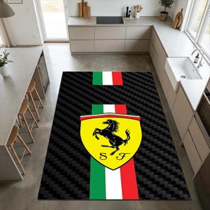 Könnte beinhalten: Ein rechteckiger Teppich mit schwarzem Carbonfaser-Muster und einem vertikalen Streifen in den italienischen Nationalfarben Grün, Weiß und Rot. Mittig befindet sich ein gelbes Wappen mit schwarzem springenden Pferd und S F.