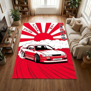 May include: A red and white area rug featuring a red sports car drifting on a red background. The rug has a Japanese-inspired design with a rising sun and Japanese text.