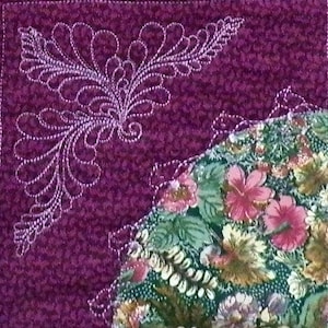 May include: A quilted textile featuring a detailed white embroidered design on a deep purple background. The design includes a floral pattern and a section of fabric with a floral print in shades of pink, green, and yellow.