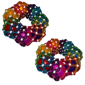 Könnte beinhalten: Zwei farbenfrohe, regenbogenfarbene Perlen-Fidget-Spielzeuge. Jedes Spielzeug ist ein Ring aus verbundenen Perlen in einer Vielzahl von Farben, darunter Rot, Orange, Gelb, Grün, Blau und Lila. Die Perlen sind durch ein weißes Gitter verbunden.