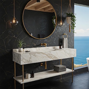 May include: A modern bathroom with a marble vanity and gold fixtures. The vanity has a rectangular sink and a lower shelf. A round gold mirror hangs above the sink, and a window offers a view of the ocean.