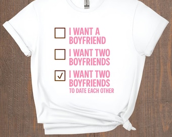 May include: White t-shirt with the text "I WANT A BOYFRIEND", "I WANT TWO BOYFRIENDS", and "I WANT TWO BOYFRIENDS TO DATE EACH OTHER" in pink. The shirt has a brown check box graphic.
