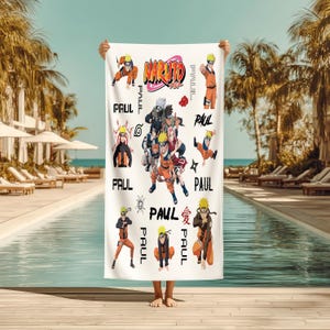 May include: White beach towel featuring multiple illustrations of characters from the anime series Naruto. The towel has the word "Naruto" in orange and pink, along with the name "Paul" in black.