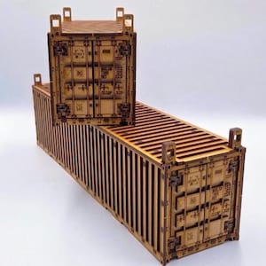 Peut inclure: Deux conteneurs d'expédition miniatures fabriqués en bois brun clair découpé au laser. Les conteneurs présentent des panneaux latéraux ondulés verticaux, des mécanismes de verrouillage de porte détaillés et des marquages techniques gravés.