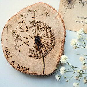 May include: A wooden slice with a burned design of a dandelion with the words "Make a Wish" around the bottom.