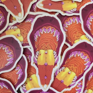 May include: A collection of stickers featuring a stylized open mouth design with sharp, pink teeth, a yellow tongue, and a red interior. The stickers have a white border and are scattered across the image.