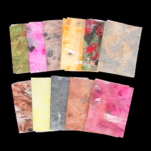 May include: A collection of eleven rectangular sheets of paper featuring various abstract patterns and colors including green, bright pink, brown, yellow, red, black, and grey. Each sheet displays a unique, textured, and marbled appearance.