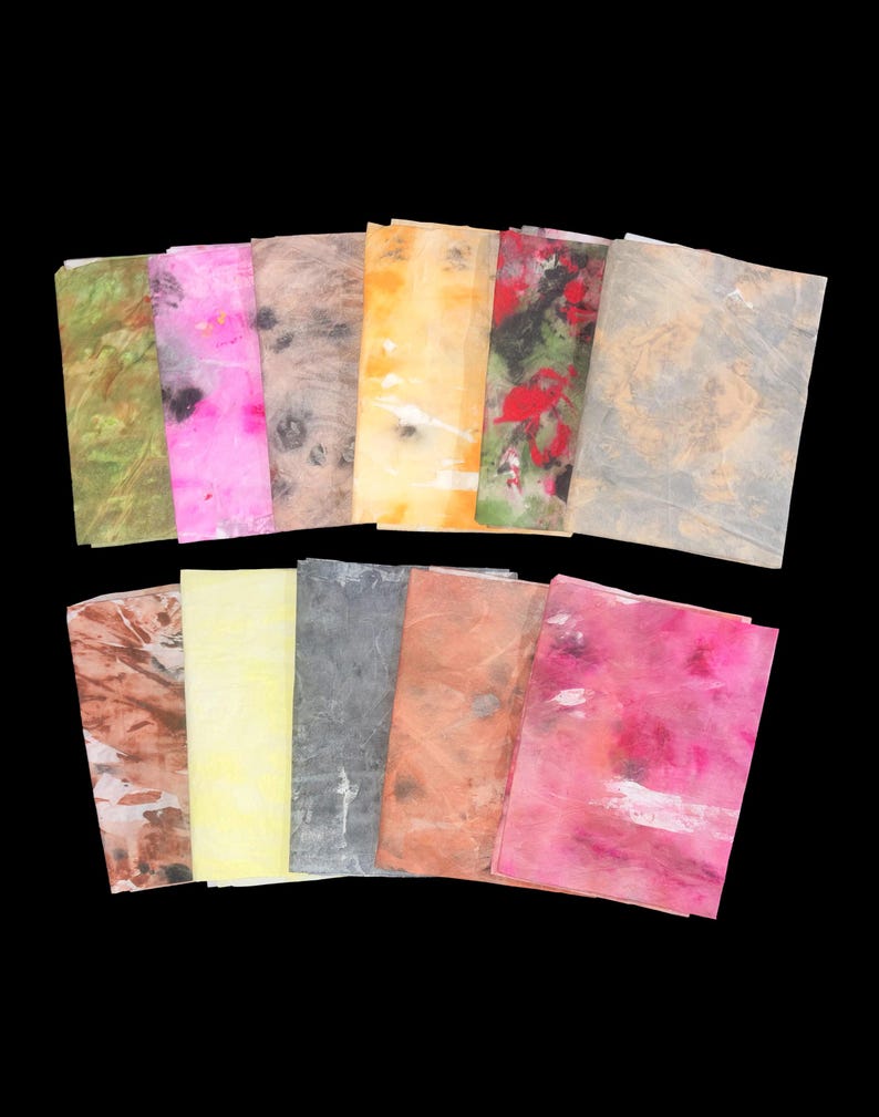May include: A collection of eleven rectangular sheets of paper featuring various abstract patterns and colors including green, bright pink, brown, yellow, red, black, and grey. Each sheet displays a unique, textured, and marbled appearance.