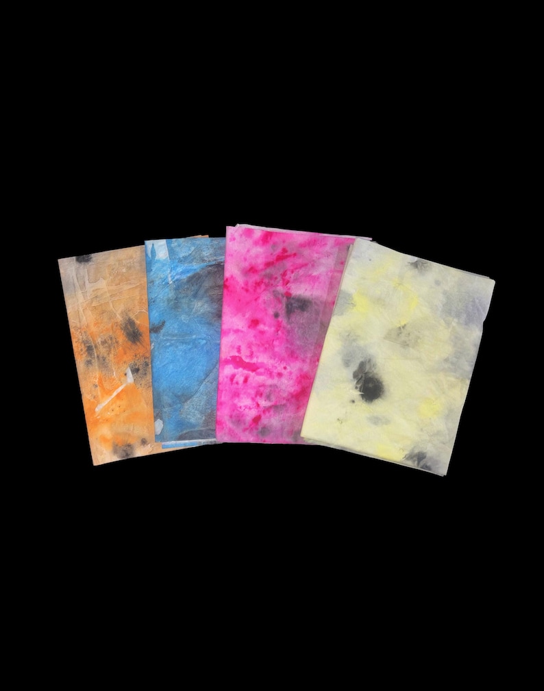 May include: Four rectangular sheets of thin, translucent paper arranged in a fan shape. The sheets feature abstract, mottled patterns in vibrant colors including orange, blue, hot pink, and pale yellow, all accented with dark gray or black ink spots.