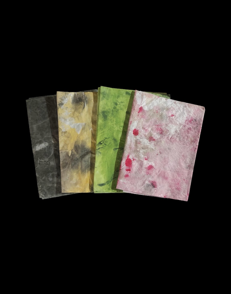 May include: A set of four rectangular sheets of textured paper arranged in a fan shape. The sheets feature marbled patterns in shades of dark gray, muted yellow, vibrant lime green, and a light pink with scattered deep red and white accents.