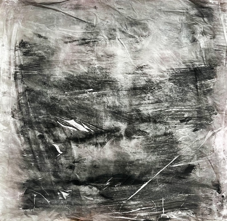 May include: A square piece of translucent, crinkled material featuring a monochromatic abstract design. The surface displays layered, horizontal brushstrokes in varying shades of charcoal, gray, and black, creating a textured, weathered appearance.