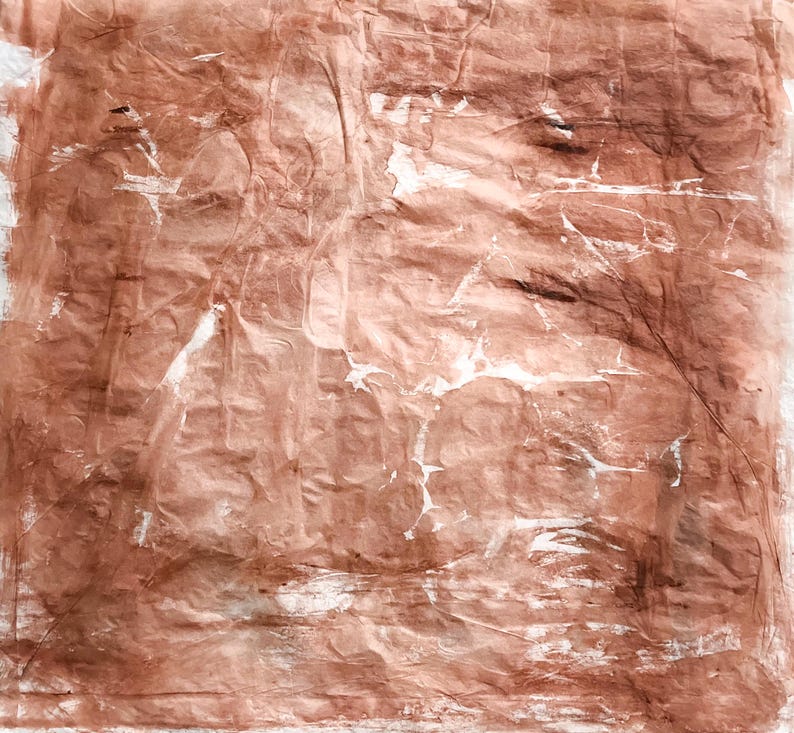 May include: A square piece of textured paper with a wrinkled surface, featuring a monochromatic terracotta brown color palette with subtle white highlights and streaks distributed across the uneven, creased material surface.