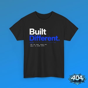 May include: A black short-sleeved t-shirt featuring the white text Built and blue text Different. Below this, a code bracket symbol appears next to the text: NOT THE SAME. NEVER WAS, BUILT TO STAND APART. The shirt has a crew neckline and a standard fit.