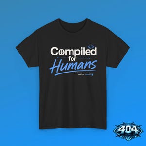 May include: A black short-sleeve t-shirt featuring the white text Compiled with code brackets, the blue script text Humans, and the smaller white text designed with logic, made to connect. The shirt has a crew neckline and a standard fit.