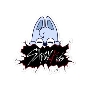 May include: A sticker with a light blue cartoon character peeking from a black hole, with the text "Stray Kids" in white and red. The character has large ears and closed eyes.