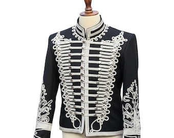 May include: Black military-style jacket with white decorative trim and silver-colored buttons. The jacket features ornate white embroidery on the sleeves and around the collar. The jacket is displayed on a mannequin.