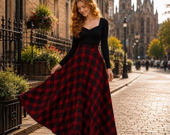 Peut inclure: Un haut noir à manches longues avec une encolure en cœur associé à une jupe longue taille haute à motif écossais rouge et noir. La jupe présente une silhouette évasée et ample qui descend jusqu'au sol, créant un style classique.