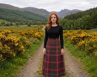 Peut inclure: Une jupe longue taille haute avec un motif tartan à carreaux rouges, verts et jaunes, associée à un haut noir simple à manches longues. La jupe descend jusqu'aux chevilles avec une ceinture structurée, et le haut présente une encolure ronde.