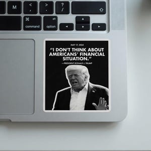 May include: A white sticker on a laptop featuring a black and white image of Donald Trump with a quote: "I DON'T THINK ABOUT AMERICANS' FINANCIAL SITUATION." The text includes the date May 17, 2024.