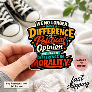 May include: A die-cut sticker or magnet featuring the text WE NO LONGER HAVE A DIFFERENCE OF POLITICAL OPINION WE HAVE A DIFFERENCE IN MORALITY in bold, multi-colored lettering with orange, red, and teal accents against a black background.