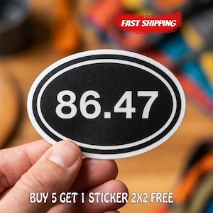 May include: Oval sticker with a black background and white border. The number "86.47" is printed in white. The text "BUY 5 GET 1 STICKER 2X2 FREE" is printed at the bottom. The words "FAST SHIPPING" are printed at the top.