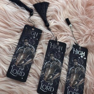 May include: Three black bookmarks with a silver chain and tassel. Each bookmark features a black and white illustration of a man with tattoos and the text "HIGH LORD".
