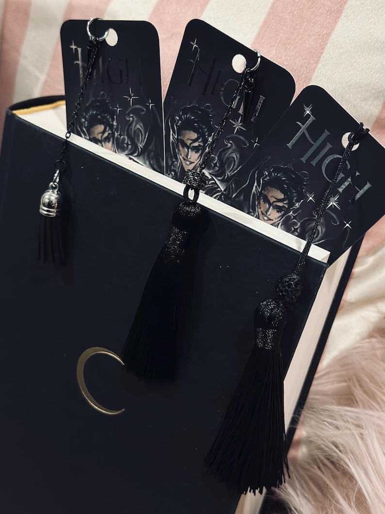 May include: Three black bookmarks with silver chains and black tassels. Each bookmark features a black and white illustration of a person with the word "High" printed on the bookmark.