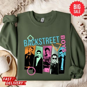 May include: Olive green sweatshirt featuring the text "BACKSTREET BOYS" in a retro font with a colorful design. The sweatshirt has a graphic of the band members in individual panels. A "BIG SALE" sticker is visible.