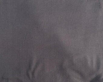 May include: Dark gray fabric with a slightly textured surface. The fabric appears to be a solid color, with subtle variations in tone and visible folds. The material is likely used for clothing or home decor.