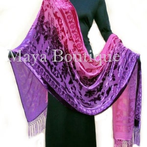 May include: A purple and pink ombre silk shawl with a floral pattern and fringe. The shawl is draped over a black dress.