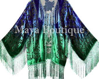 May include: A blue, green, and black velvet kimono with a floral pattern and fringe trim. The kimono has a gradient color effect, starting with blue at the top and fading to green at the bottom. The fringe is a light green color.